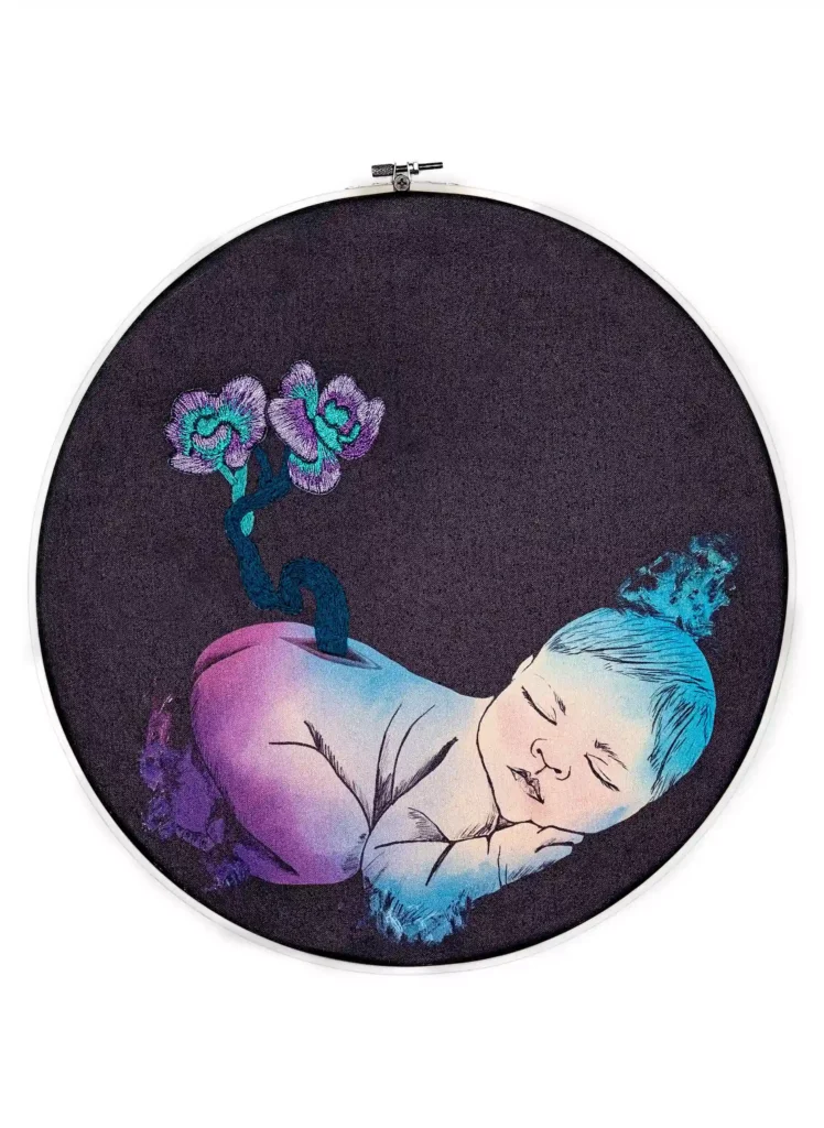 Ilustración digital impresa sobre lienzo e intervenida con bordado. La imagen muestra un bebe en colores cósmicos del que le salen dos pequeñas orquídeas de su espalda.